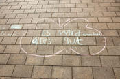 Gemalte Zuversicht: „Es wird alles gut“, haben Kinder mit Kreide auf den Boden vor der Holzlaube geschrieben.