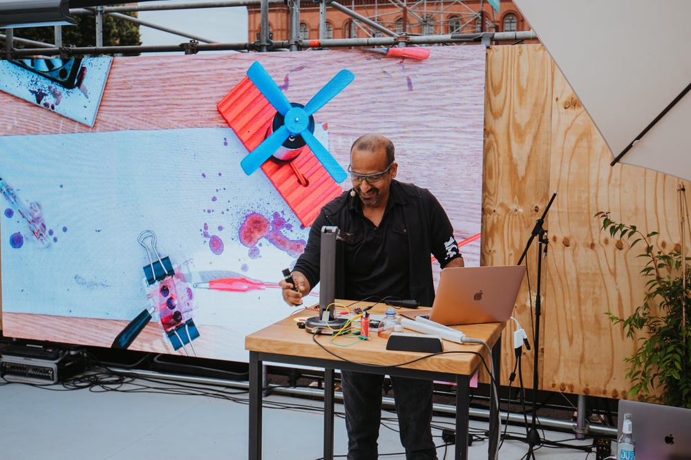 „Ich hol euch mal ein bisschen näher ran“: Chemiedidaktiker Amitabh Banerji gehörte zu den drei Slammern und zwei Slammerinnen, die am Sonnabend auf der Bühne standen. Der Alumnus der Freien Universität ist Professor an der Universität Potsdam.