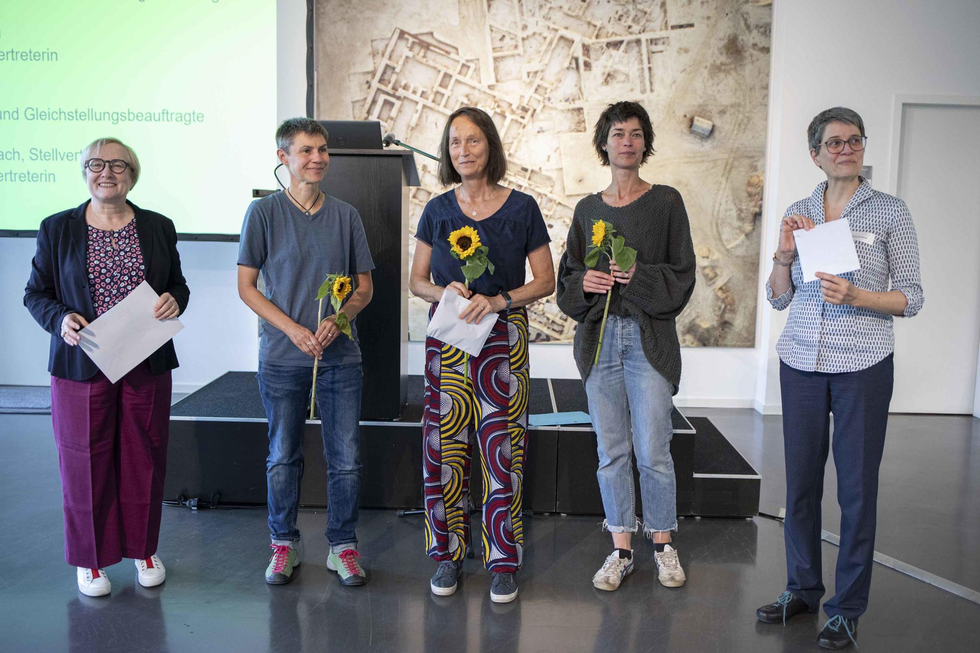 Mit Sonnenblumen begrüßt: Die Frauen- und Gleichstellungsbeauftragten am FB Mathematik und Informatik. V.l.n.r.: Erste Vizepräsidentin, Sera Renée Zentiks, Maren-Wanda Wolf (Stv.), Christine Scharlach (Stv.), Zentrale Frauenbeauftragte C. Tomberger.