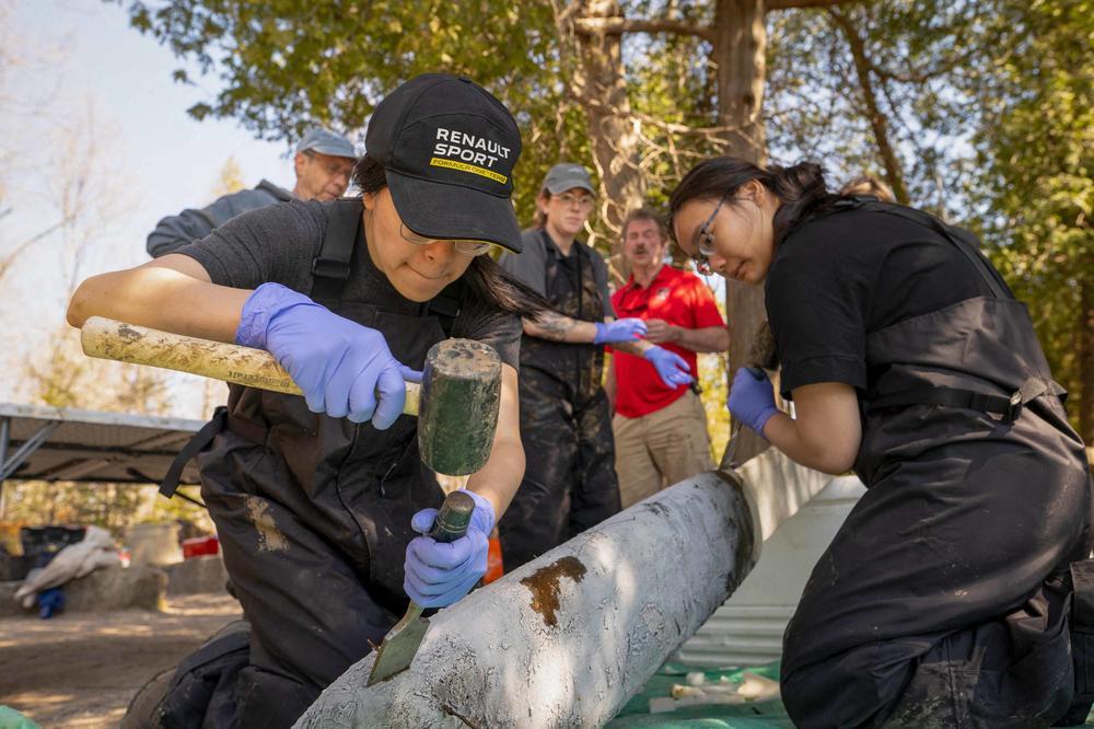 A team of researchers from Carleton University and Brock University removes frozen sections from a sedimentary core taken from the bottom of Crawford Lake.