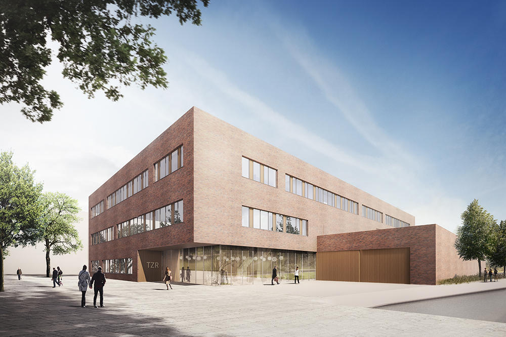 Modernes Backsteingebäude. Flachdach, große Glasfenster. Im Erdgeschoss sind durch die großen Fenster kugelige Lampen erkennbar.