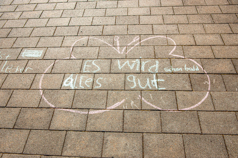 Der Optimismus bleibt: „Es wird alles gut“ haben Kinder mit Kreide auf den Boden vor der Holzlaube geschrieben.