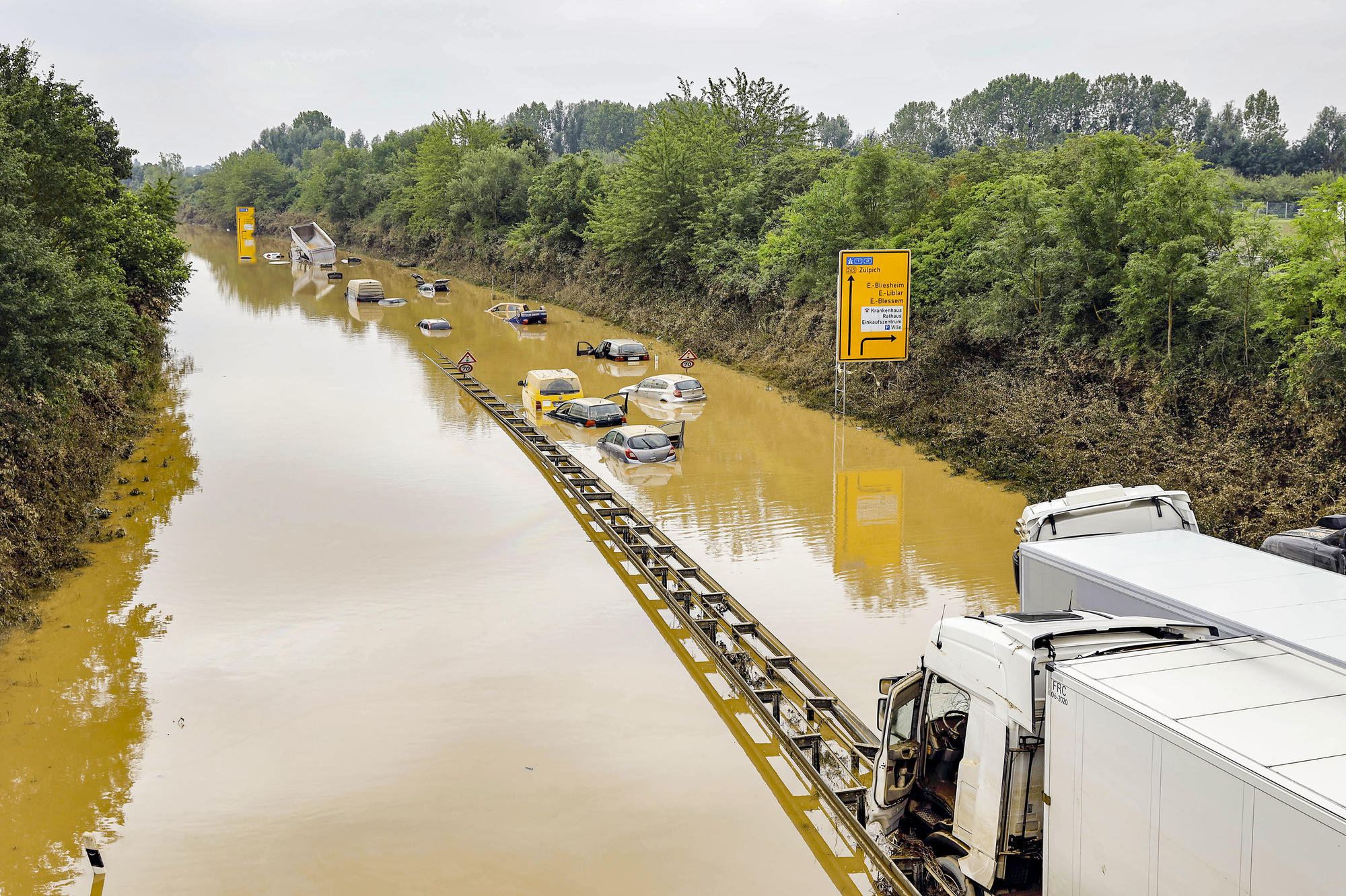 Bei den Bergungsarbeiten zerstörter Autos in Erftstadt-Liblar im Juli 2021 kommen auch Sonar, Bundeswehrpanzer und Taucher zum Einsatz. Die Fahrer der Autos und Lastwagen waren von den Massen an Wasser überrascht worden.